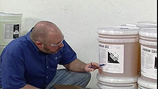 A man reading a label on a barrel