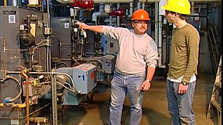 A man showing an employee an electrical box