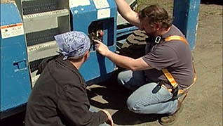 A man showing a co-worker how to operate a sissor lift