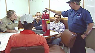 A man showing employees how to use a fire extinguisher