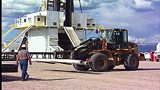 Forklift moving with man watching