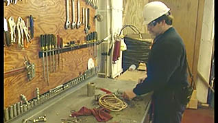 A man standing in front of a clean workbench