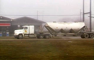 A large truck hauling a tank behind it demonstrates how to judge distance and speed when hauling large cargo in a heavy truck.