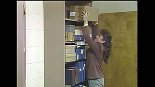 A women properly stacking a box on a shelf