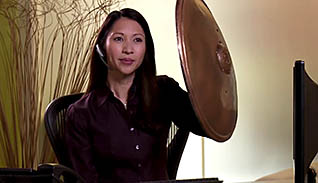 A woman holds up a shield while dealing with an angry customer on the phone