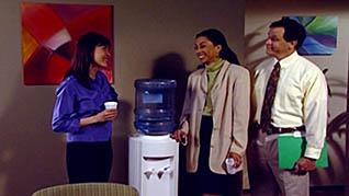Coworkers communicating in a positive manner by the water cooler