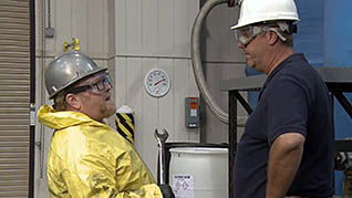 Two men talking wearing PPE